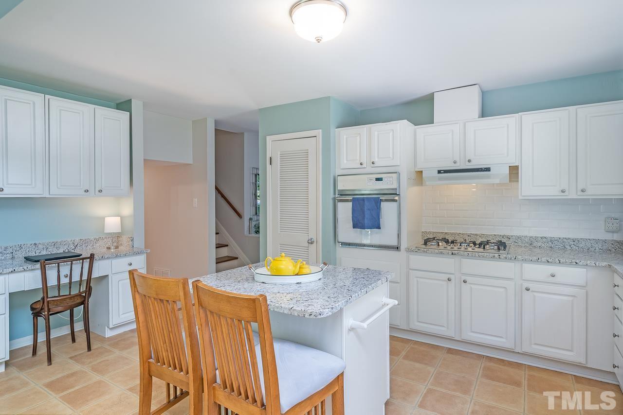 505 Old Farm Road Raleigh, NC 27606 - Photo 6 of 22 a kitchen with stainless steel appliances granite countertop a table chairs sink and cabinets