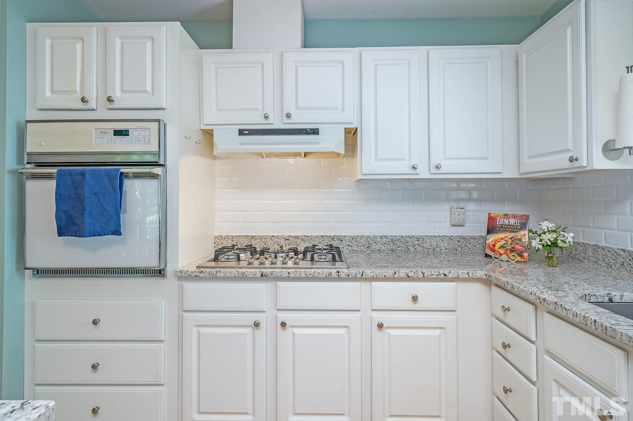505 Old Farm Road Raleigh, NC 27606 - Photo 10 of 22 a kitchen with granite countertop white cabinets and white appliances