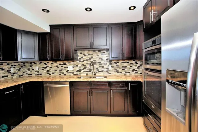 a kitchen with stainless steel appliances granite countertop a sink stove and refrigerator