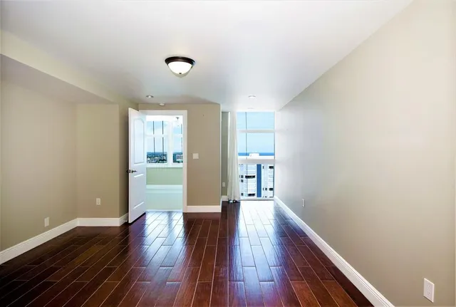 a view of an empty room with wooden floor