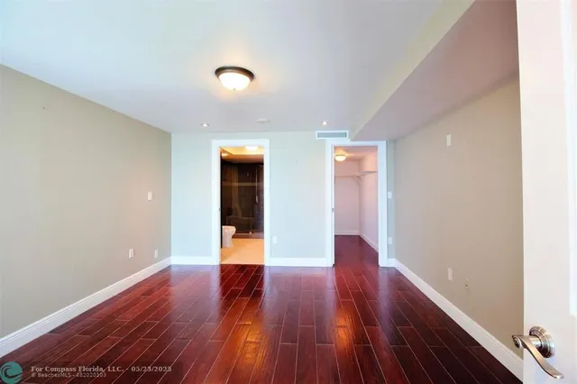 a view of an empty room with wooden floor