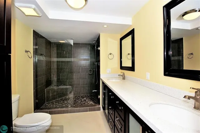a bathroom with a double vanity sink toilet and shower
