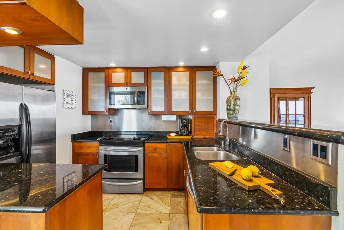 1661 Pee Road, Unit I310 Koloa, HI 96756 - Photo 6 of 30 a kitchen with stainless steel appliances granite countertop a stove top oven a sink and a counter space