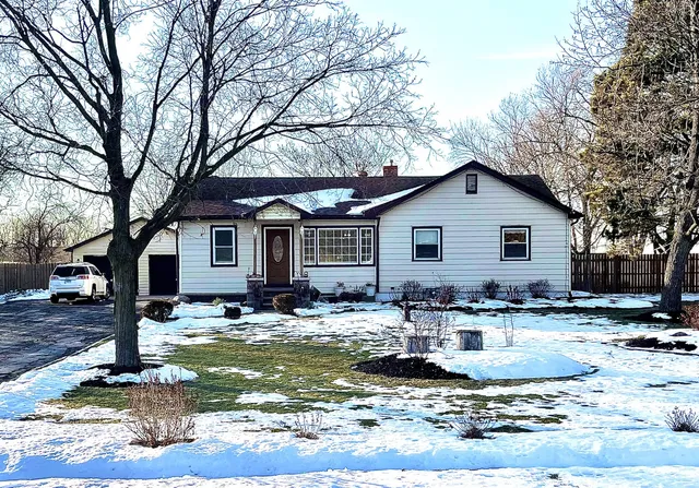 a front view of house with yard and trees in the background