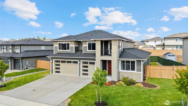 a front view of a house with a yard and garage