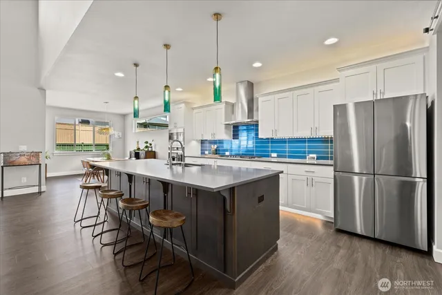 a large kitchen with stainless steel appliances kitchen island wooden cabinets and a sink