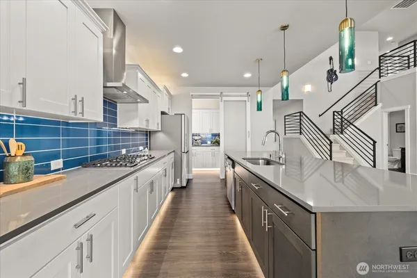 a large kitchen with stainless steel appliances kitchen island wooden cabinets and a sink
