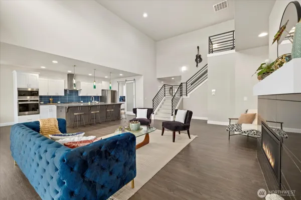 a living room with furniture wooden floor and a kitchen view