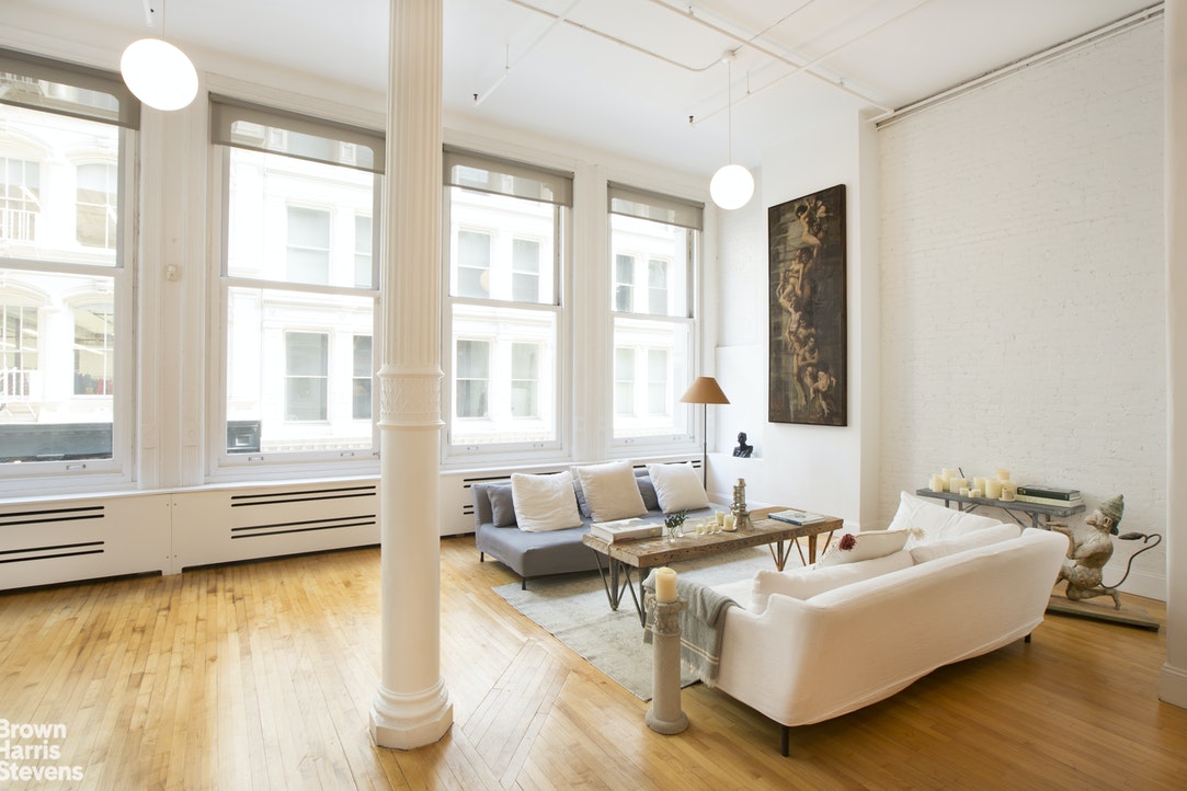 a living room with furniture and floor to ceiling windows