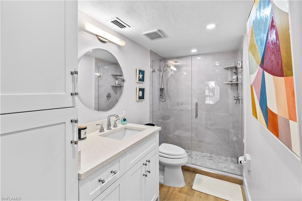 377 Vanderbilt Beach Road, Unit 102 Naples, FL 34108 - Photo 16 of 19 a bathroom with a sink a toilet and shower