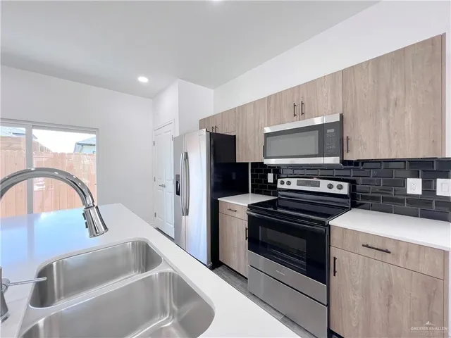 a kitchen with kitchen island a sink appliances and cabinets