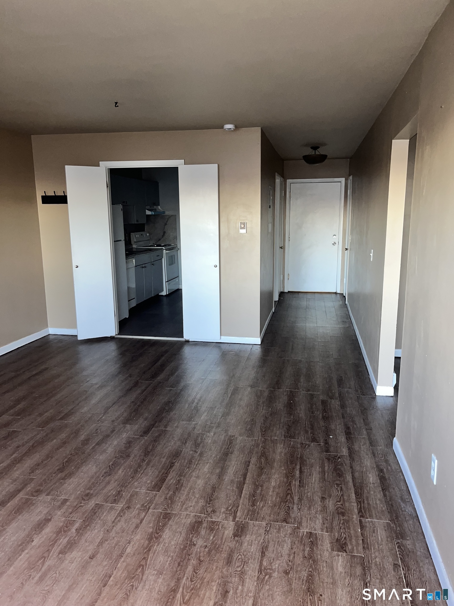 1730 State Street, Unit 407 Hamden, CT 06517 - Photo 1 of 8 a view of empty room with wooden floor and kitchen