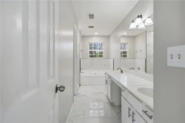 a spacious bathroom with a bathtub sink and mirror