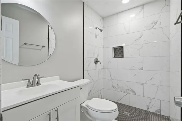 a bathroom with a sink toilet a mirror and shower