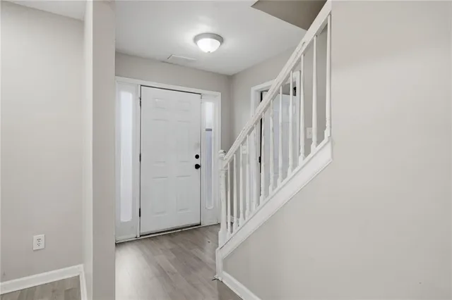 a view of a hallway with wooden floor and entryway