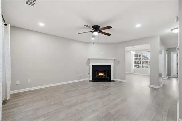 a view of an empty room with a fireplace and a window
