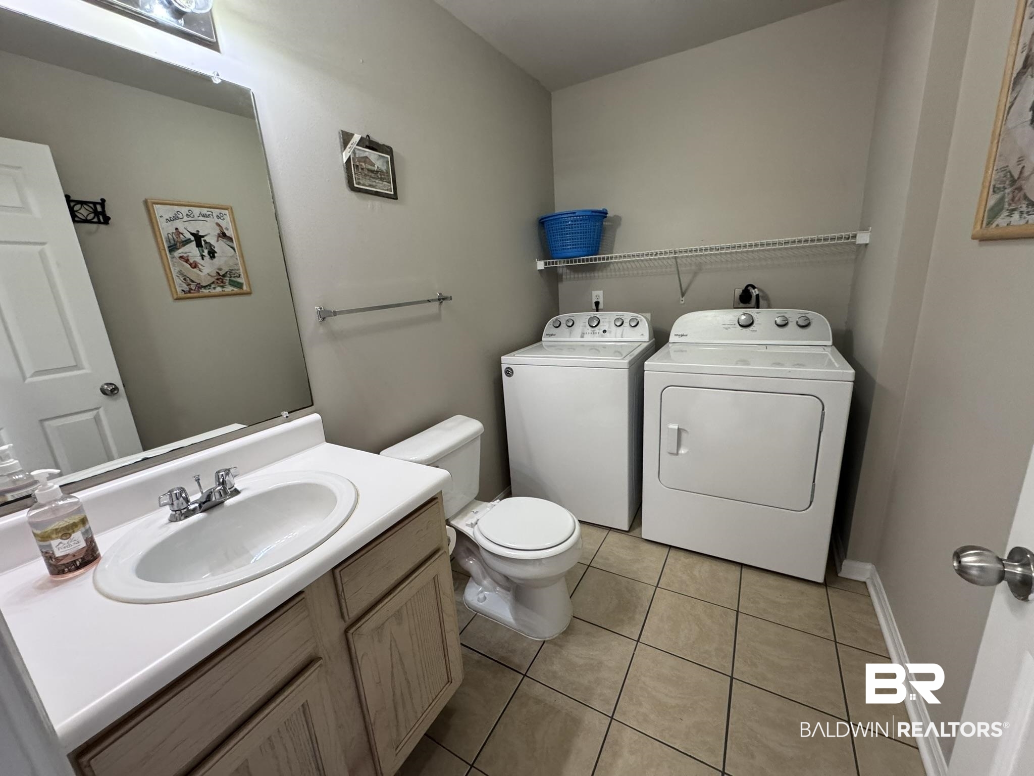 1517 Regency Road, Unit 131 Gulf Shores, AL 36542 - Photo 3 of 21 Bathroom with vanity, washing machine and dryer, and light tile patterned floors