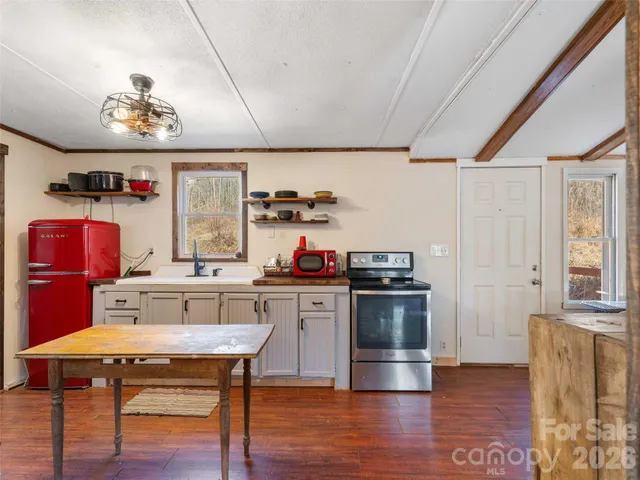 a kitchen with a stove a refrigerator and wooden floor