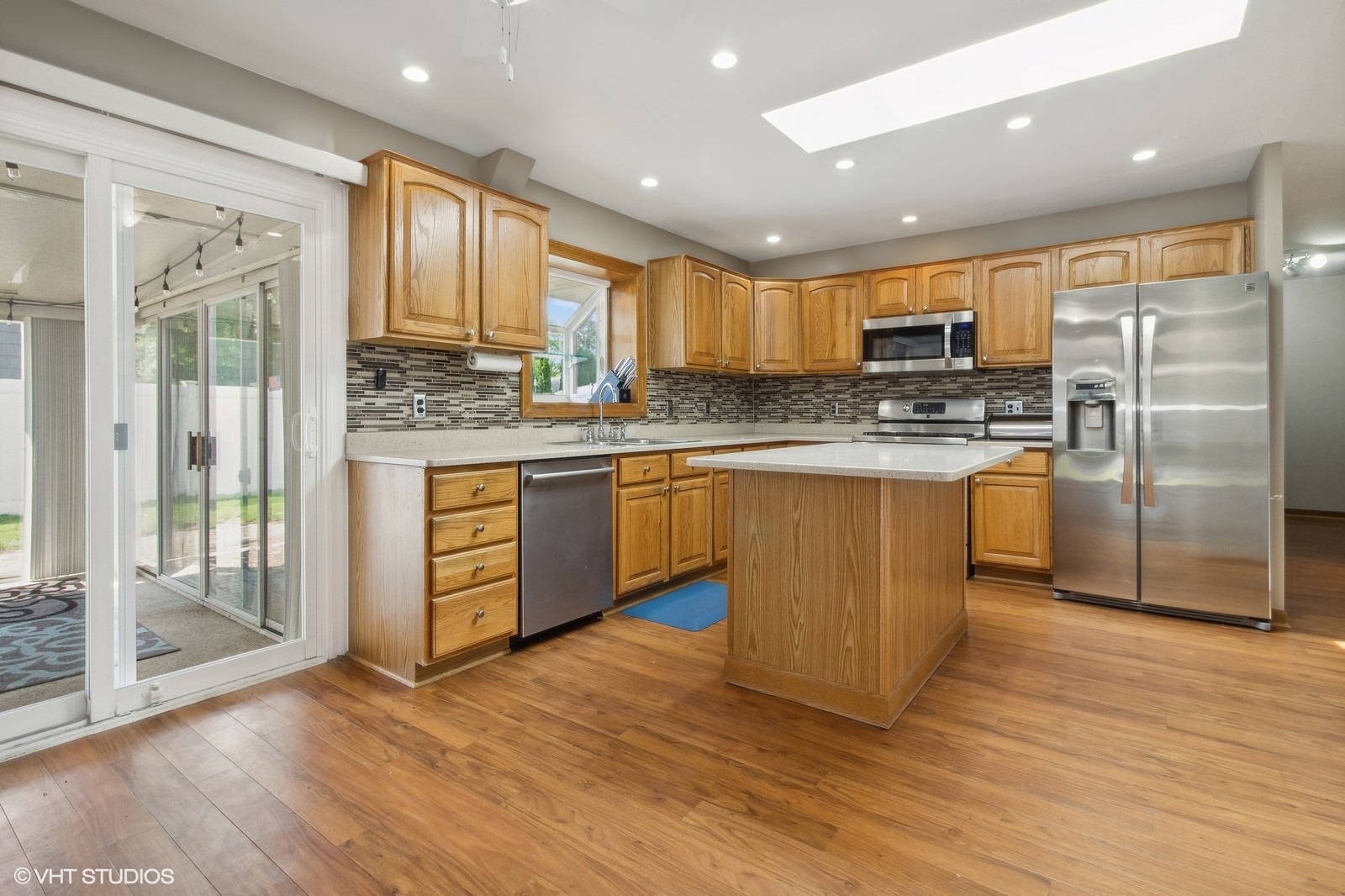 16 Old Post Road Montgomery, IL 60538 - Photo 4 of 21 a kitchen with stainless steel appliances granite countertop a stove top oven a refrigerator a sink and a dining table with wooden floor