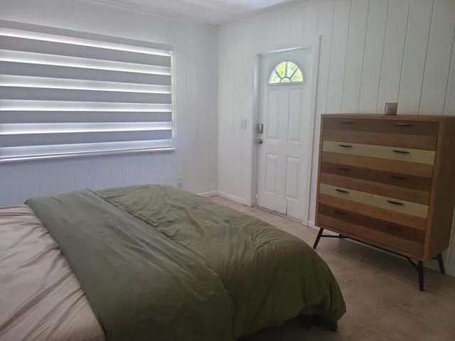 a bed sitting in a bedroom next to a window