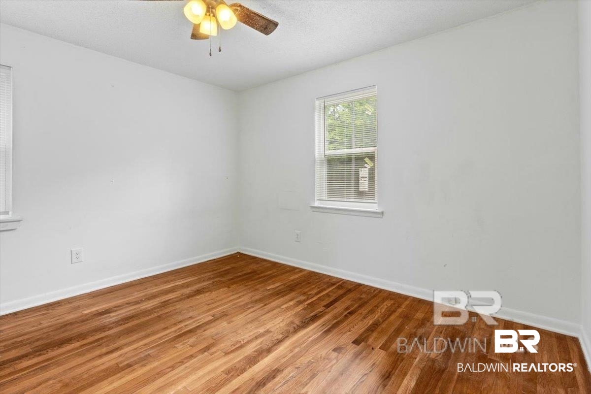 29397 Loper Road Loxley, AL 36551 - Photo 14 of 22 Empty room featuring a textured ceiling, wood finished floors, and ceiling fan