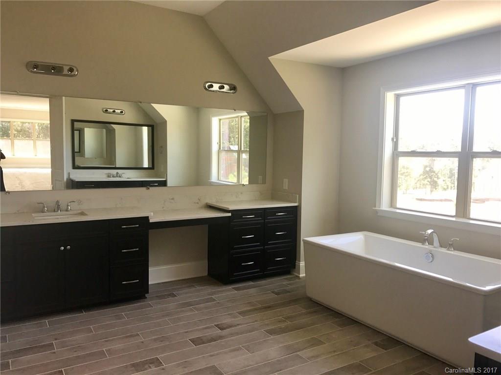 4013 Flowering Peach Road, Unit 9 Marvin, NC 28173 - Photo 9 of 12 a bathroom with a tub double vanity sink and mirror