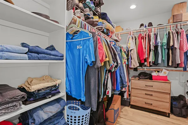 a view of walk in closet with clothes and shoes