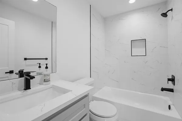 a bathroom with a sink a toilet and bathtub