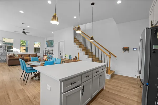 a living room with stainless steel appliances kitchen island a table chairs and a view of living room