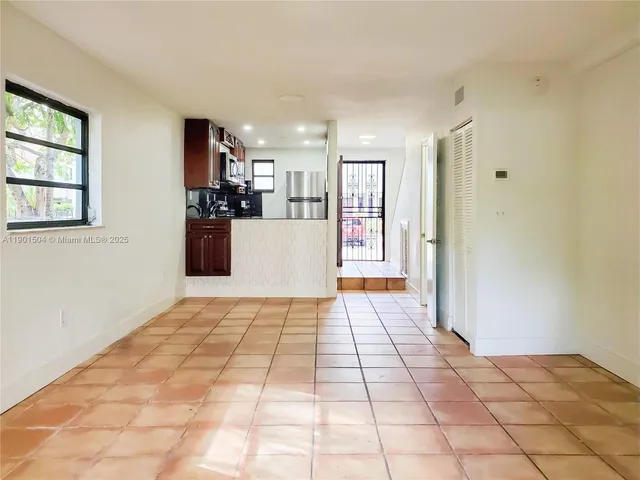 a view of a hallway with wooden floor and cabinets