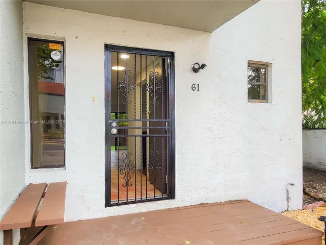 a view of a hallway with wooden floor and a living room