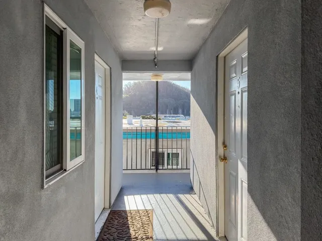 a view of a hallway with wooden floor and door