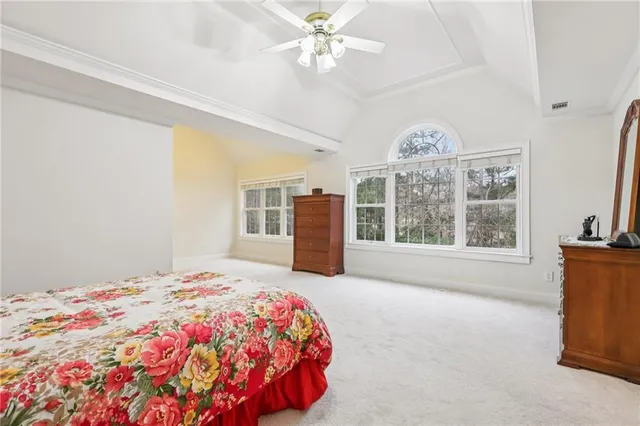 a bedroom with a large bed and a chandelier