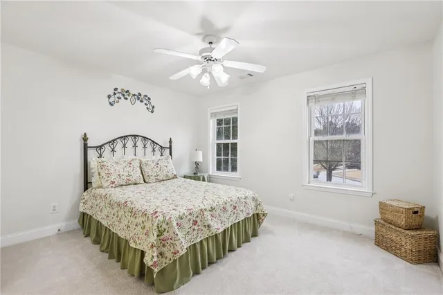 a bedroom with a bed a chandelier and dresser