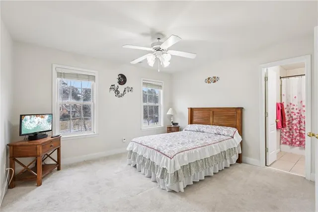 a bedroom with a bed a chandelier and dresser