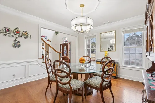 a view of a dining room with furniture wooden floor and a chandelier