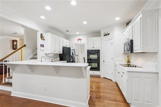 a large white kitchen with stainless steel appliances