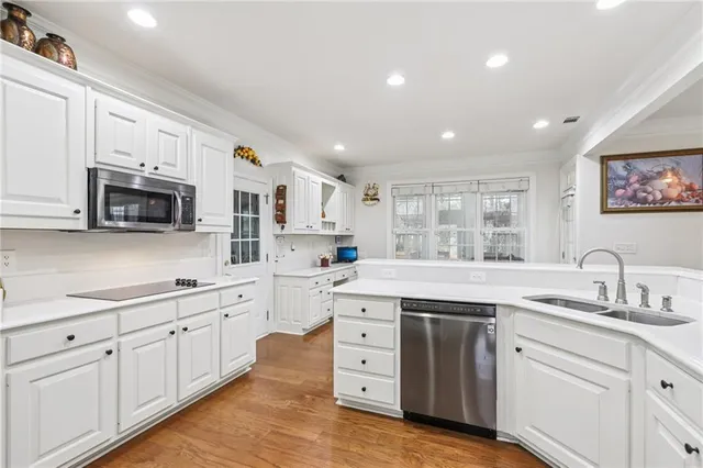 a kitchen with white cabinets and sink