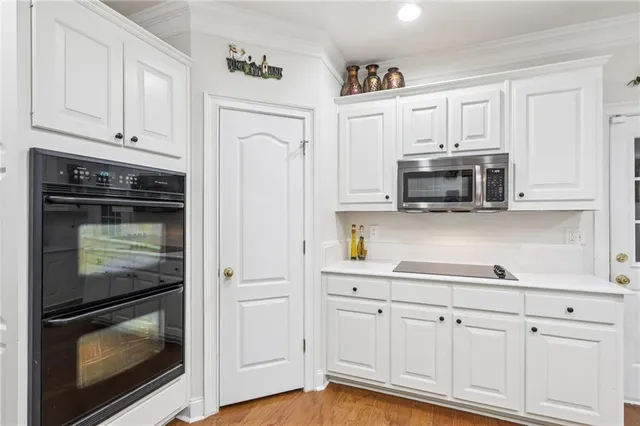 a kitchen with white cabinets and appliances