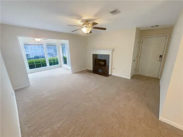 a view of an empty room with a fireplace and a window