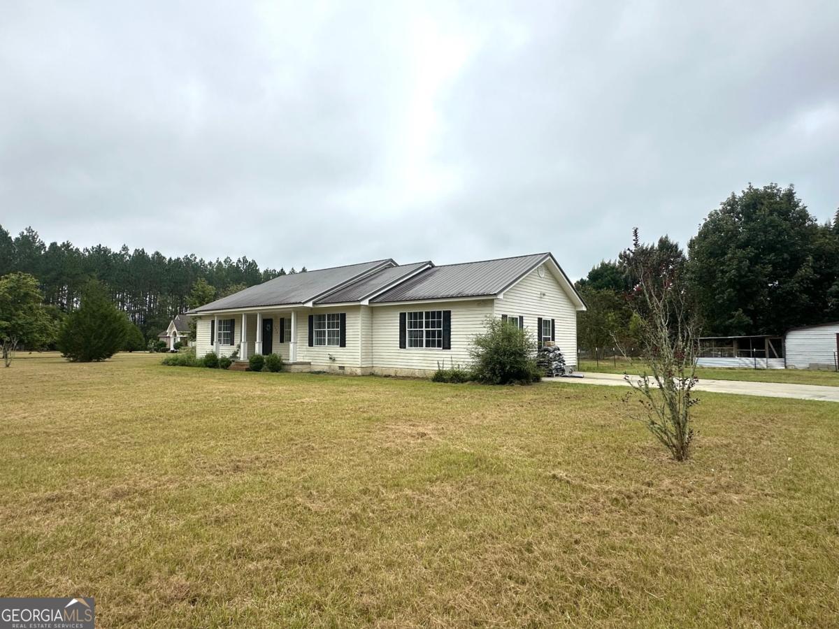 1296 Boone Road Adel, GA 31620 - Photo 19 of 20 a front view of a house with a garden