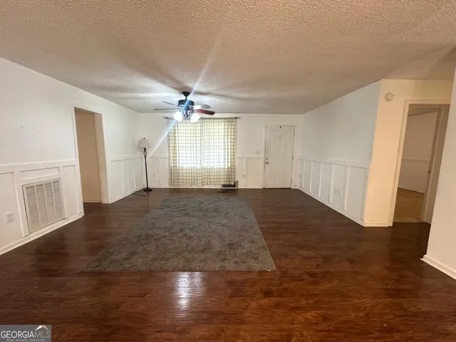 an empty room with wooden floor and staircase