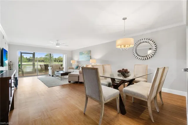 a living room with furniture a large window and a chandelier