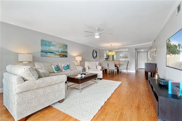 a living room with furniture wooden floor and a large window