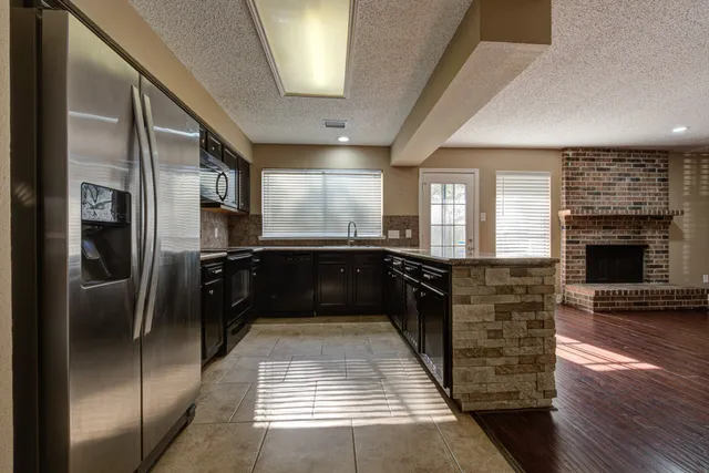 a kitchen with granite countertop a refrigerator and a stove