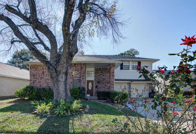 a front view of a house with a yard and potted plants