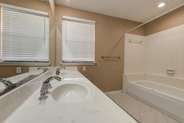 a bathroom with a tub sink and mirror