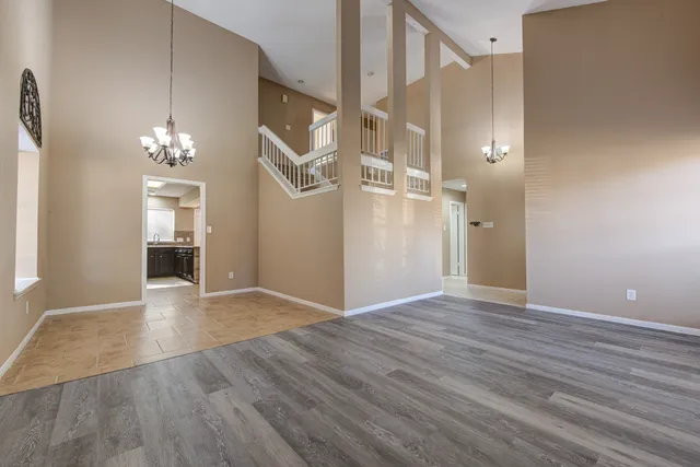 a view of a hallway with wooden floor and a chandelier
