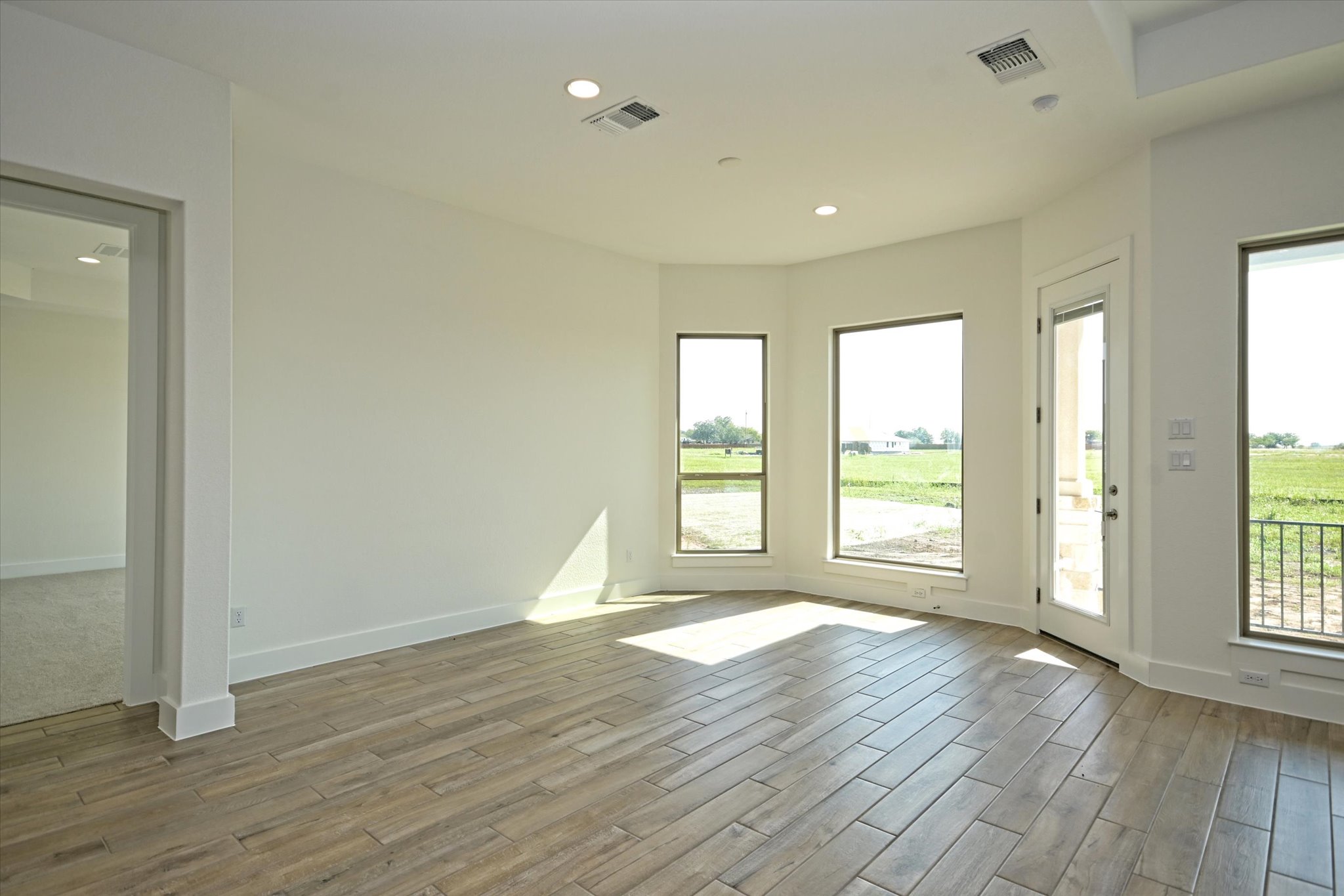 217 Scofield Avenue Georgetown, TX 78626 - Photo 13 of 31 an empty room with wooden floor and windows