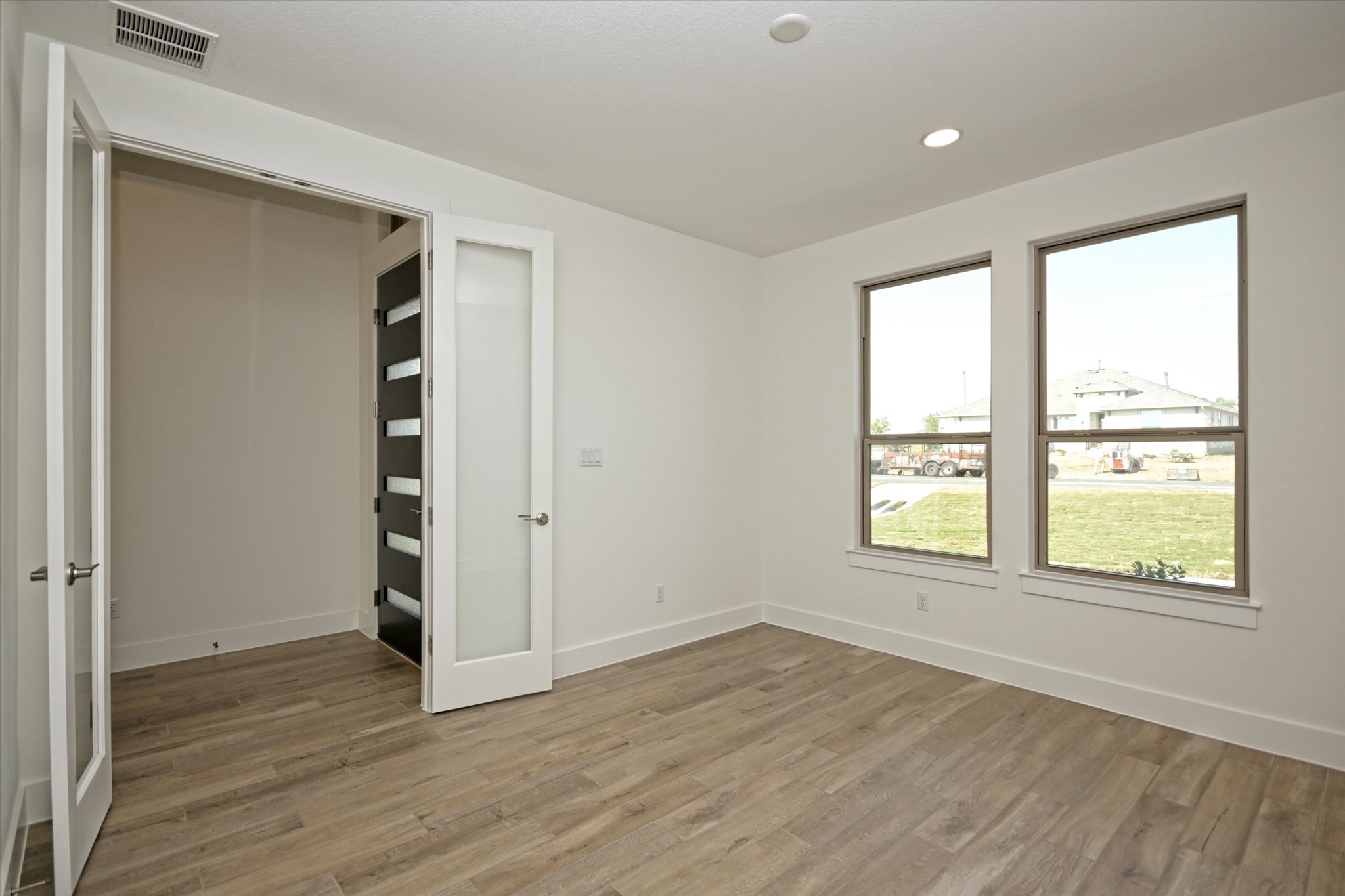 217 Scofield Avenue Georgetown, TX 78626 - Photo 4 of 31 an empty room with wooden floor and windows